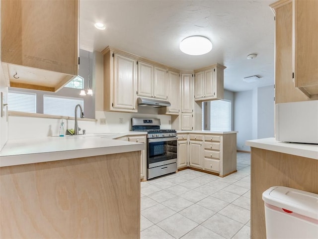 1312 Every Dr, Edmond, OK 73034 - kitchen with stainless steel gas range, under cabinet range hood, a peninsula, a sink, and light tile patterned floors