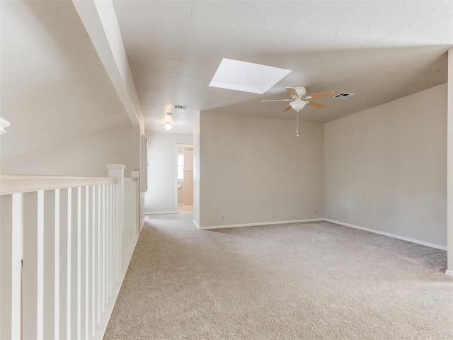 1312 Every Dr, Edmond, OK 73034 - empty room with a skylight, a ceiling fan, light carpet, and baseboards
