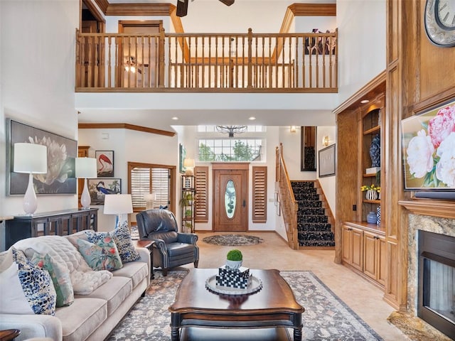205 W Waterfront Dr, Tuttle, OK 73089 - living room featuring a high ceiling, stairs, a fireplace, crown molding, and built in shelves