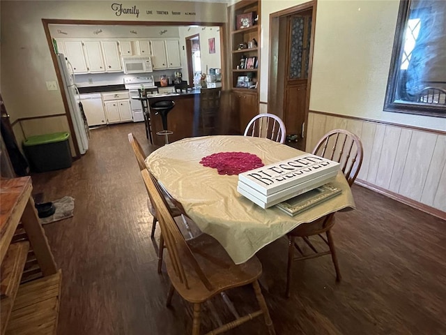 139 Sheridan Pl, Chickasha, OK 73018 - dining area featuring dark wood-style floors, a wainscoted wall, and built in shelves