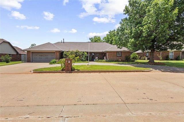 1205 Francis Ln, Kingfisher, OK 73750 - ranch-style house with curved driveway, brick siding, a front lawn, and an attached garage