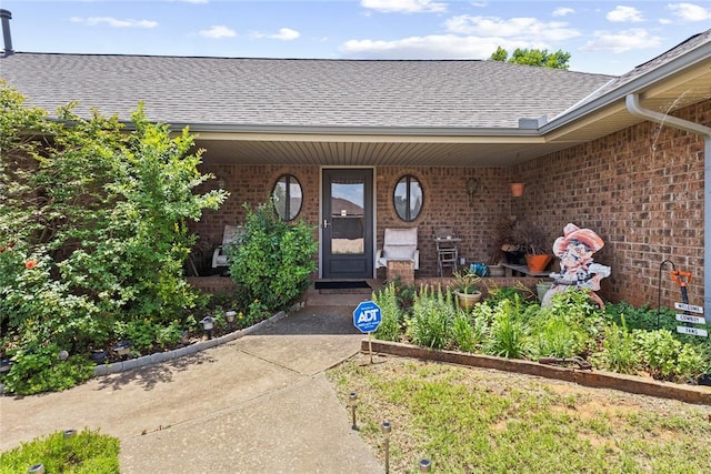 1205 Francis Ln, Kingfisher, OK 73750 - doorway to property with a shingled roof, brick siding, and a porch