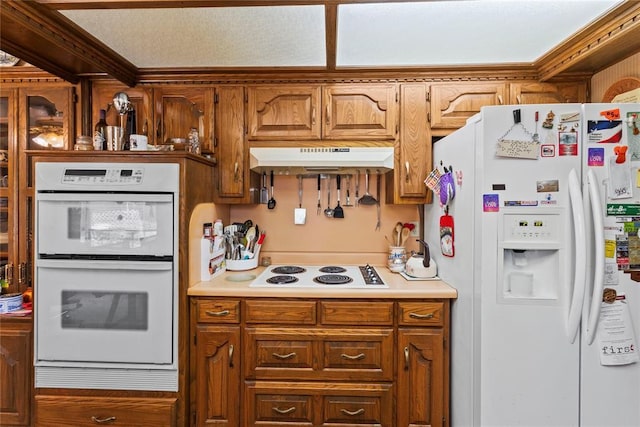 1205 Francis Ln, Kingfisher, OK 73750 - kitchen with white appliances, under cabinet range hood, light countertops, and brown cabinetry