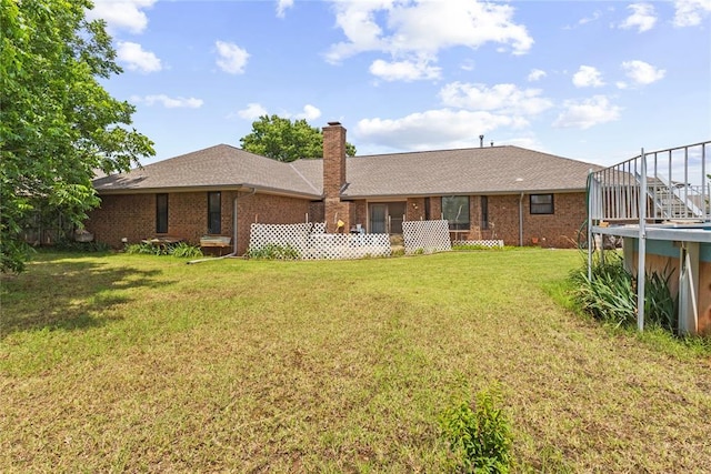 1205 Francis Ln, Kingfisher, OK 73750 - rear view of house with a lawn, brick siding, a chimney, and roof with shingles