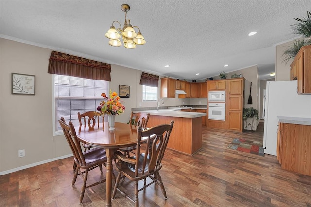 1318 N Cook St, Cordell, OK 73632 - dining space with a textured ceiling, a chandelier, crown molding, dark wood-style floors, and recessed lighting