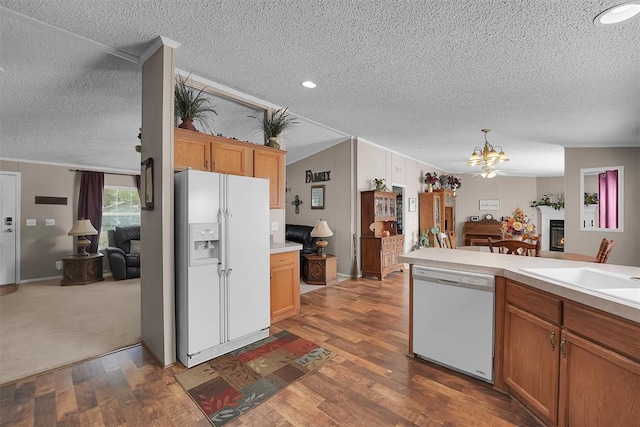 1318 N Cook St, Cordell, OK 73632 - kitchen featuring white appliances, a textured ceiling, light countertops, open floor plan, and a chandelier