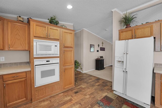 1318 N Cook St, Cordell, OK 73632 - kitchen featuring white appliances, vaulted ceiling, wood finished floors, a textured ceiling, and crown molding