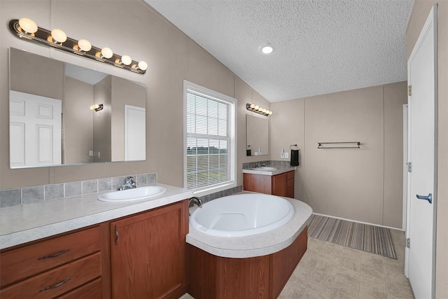 1318 N Cook St, Cordell, OK 73632 - full bath featuring a textured ceiling, two vanities, vaulted ceiling, and a bath