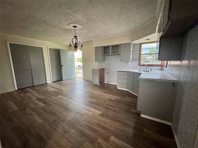1502 S 12th St, Chickasha, OK 73018 - kitchen featuring gray cabinetry, healthy amount of natural light, a chandelier, a textured ceiling, and dark wood finished floors