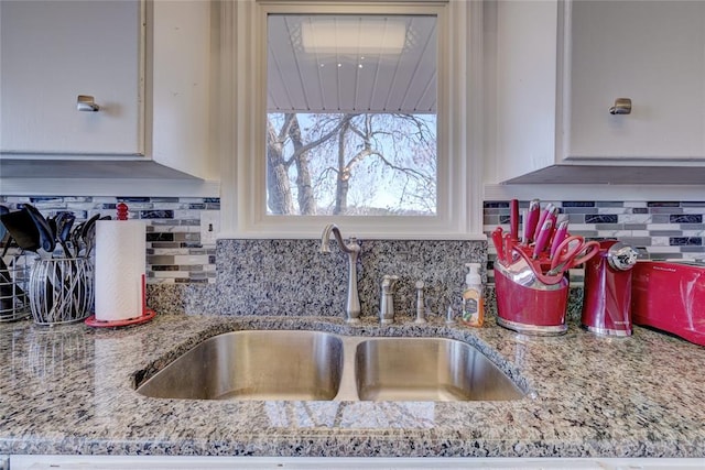 926 Park Cove Ln, Eucha, OK 74342 - kitchen view of a sink, decorative backsplash, light stone counters, and white cabinets