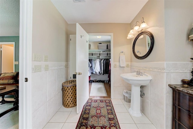 1736 Bryant Cir, Norman, OK 73026 - bathroom with tile walls, wainscoting, tile patterned floors, and a walk in closet
