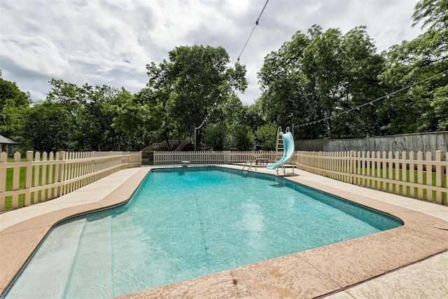 1736 Bryant Cir, Norman, OK 73026 - view of swimming pool with a water slide, view of scattered trees, and a fenced backyard