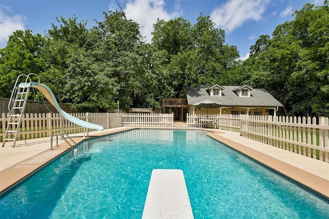 1736 Bryant Cir, Norman, OK 73026 - view of swimming pool with a water slide, a diving board, a patio area, and view of scattered trees