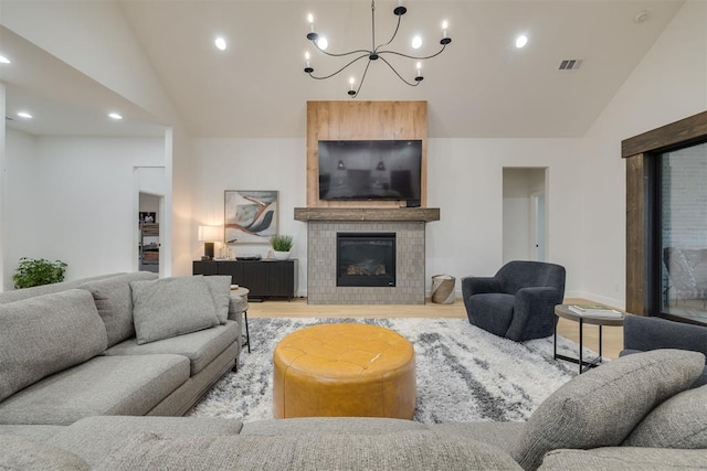 6524 NE 96th Cir, Oklahoma City, OK 73151 - living room with vaulted ceiling, light wood-type flooring, a chandelier, a tiled fireplace, and recessed lighting