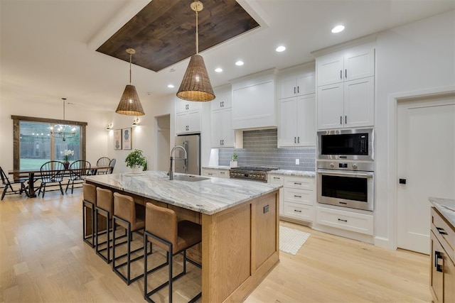 6524 NE 96th Cir, Oklahoma City, OK 73151 - kitchen featuring appliances with stainless steel finishes, a breakfast bar area, light wood-type flooring, decorative backsplash, and recessed lighting