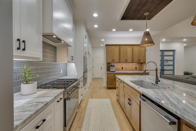 6524 NE 96th Cir, Oklahoma City, OK 73151 - kitchen with appliances with stainless steel finishes, wall chimney range hood, light wood finished floors, light stone countertops, and recessed lighting