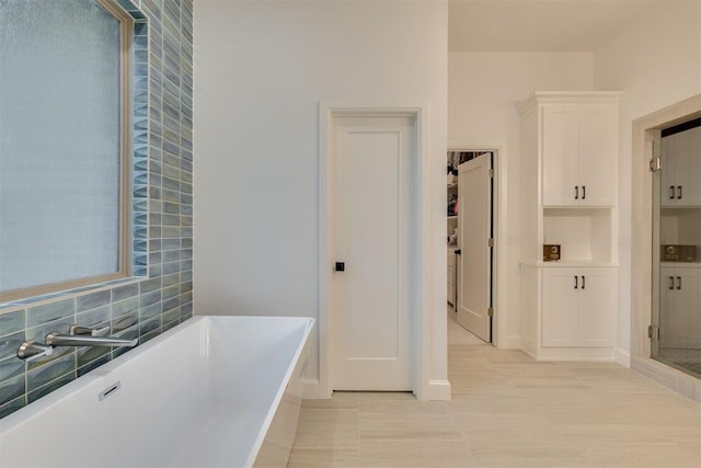 6524 NE 96th Cir, Oklahoma City, OK 73151 - bathroom with a freestanding bath, backsplash, and tile patterned flooring
