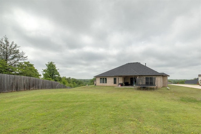 6524 NE 96th Cir, Oklahoma City, OK 73151 - rear view of property with a trampoline and brick siding