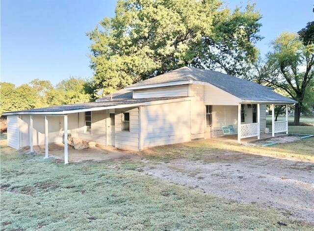 16204 Gaddy Rd, Shawnee, OK 74801 - view of side of property with covered porch, a yard, and a shingled roof