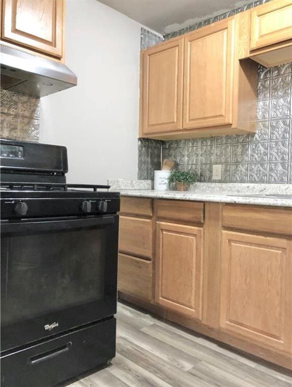 16204 Gaddy Rd, Shawnee, OK 74801 - kitchen featuring black gas range, under cabinet range hood, backsplash, light wood finished floors, and light brown cabinets