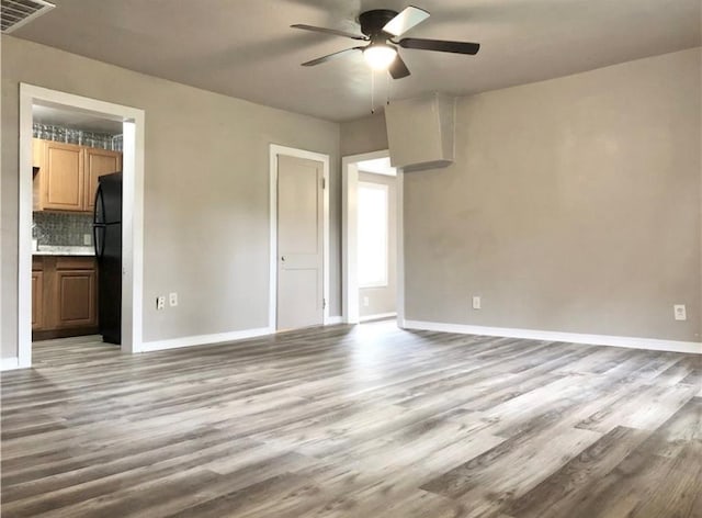16204 Gaddy Rd, Shawnee, OK 74801 - unfurnished bedroom featuring freestanding refrigerator, wood finished floors, baseboards, and a ceiling fan
