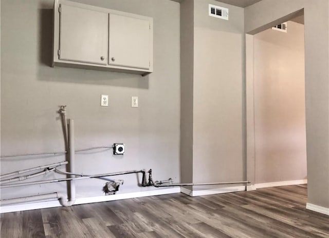 16204 Gaddy Rd, Shawnee, OK 74801 - laundry room with cabinet space, wood finished floors, and baseboards