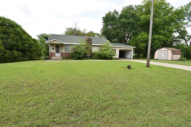 220 E Tiger Ave, Wetumka, OK 74883 - view of front facade featuring concrete driveway, a front yard, brick siding, and a chimney