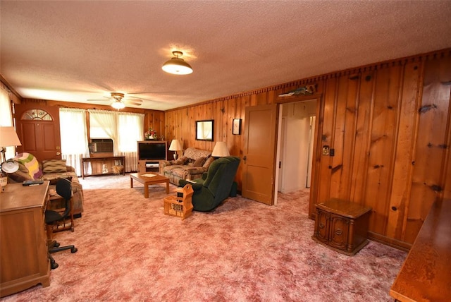 220 E Tiger Ave, Wetumka, OK 74883 - carpeted living area with a textured ceiling, ceiling fan, and wooden walls