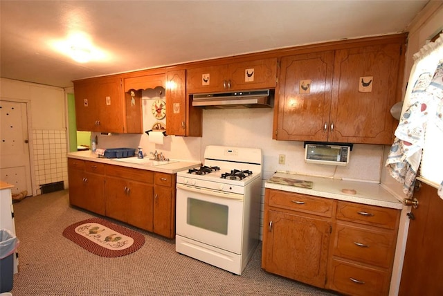 220 E Tiger Ave, Wetumka, OK 74883 - kitchen featuring white gas stove, under cabinet range hood, brown cabinets, and light countertops