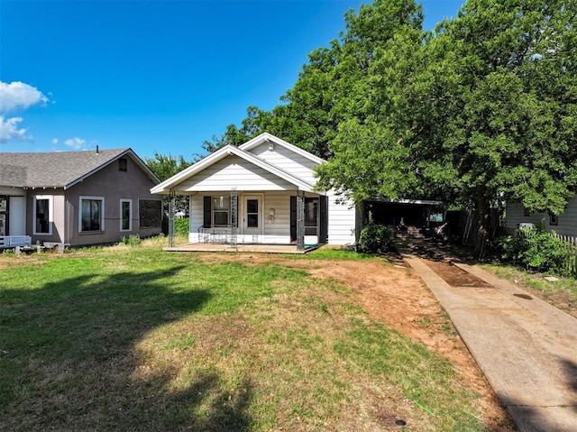 1407 S 9th St, Chickasha, OK 73018 - view of front of home with a porch, concrete driveway, and a front lawn