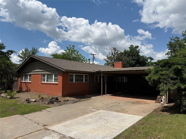 2125 Fremont Dr, The Village, OK 73120 - view of front of property with brick siding, concrete driveway, a chimney, and a carport