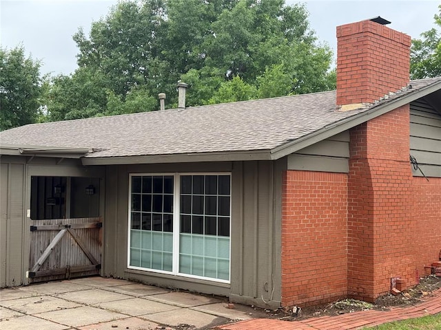 2125 Fremont Dr, The Village, OK 73120 - view of side of home featuring a shingled roof, a chimney, board and batten siding, and brick siding