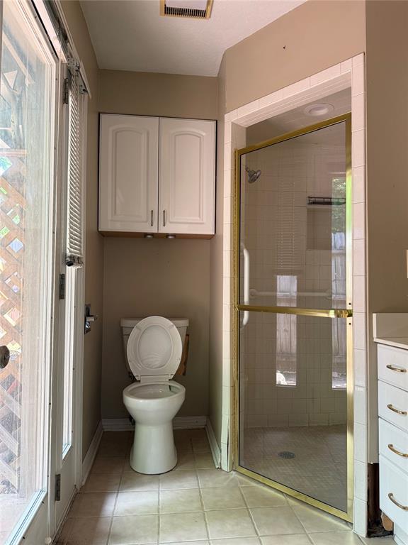 2125 Fremont Dr, The Village, OK 73120 - bathroom with toilet, a shower stall, tile patterned floors, baseboards, and vanity