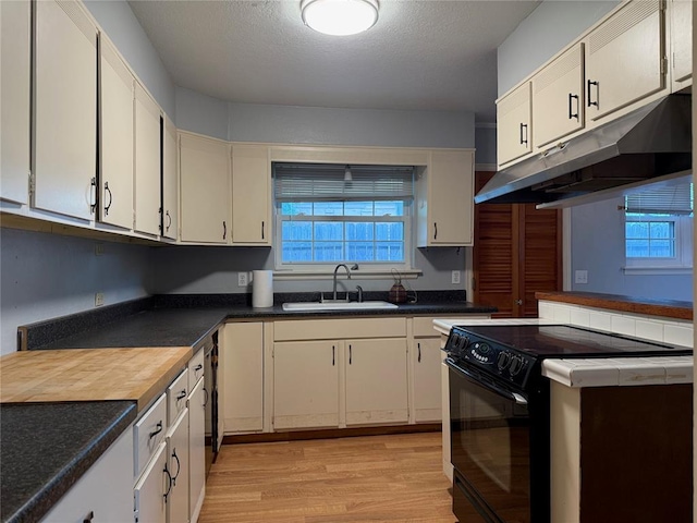 2125 Fremont Dr, The Village, OK 73120 - kitchen with a sink, black range with electric stovetop, under cabinet range hood, light wood-type flooring, and dark countertops