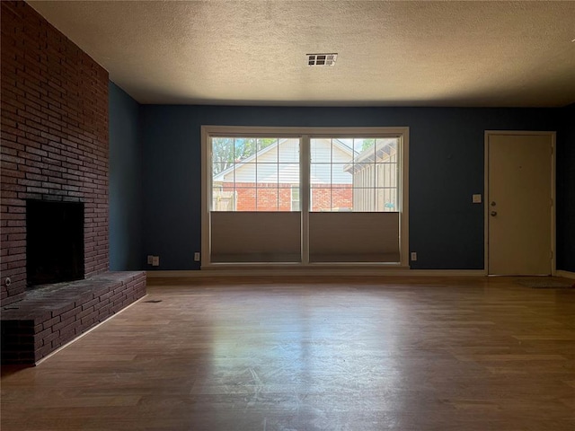 2125 Fremont Dr, The Village, OK 73120 - unfurnished living room with a textured ceiling, wood finished floors, baseboards, and a fireplace