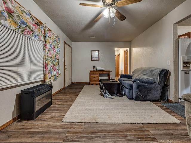 3236 SW 37th St, Oklahoma City, OK 73119 - living room with a ceiling fan, dark wood finished floors, a textured ceiling, heating unit, and baseboards