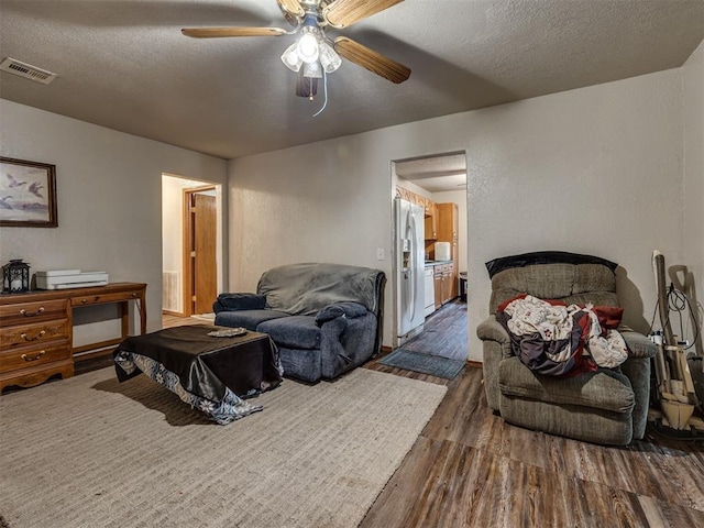 3236 SW 37th St, Oklahoma City, OK 73119 - bedroom featuring stainless steel fridge with ice dispenser, dark wood-style flooring, a textured ceiling, a ceiling fan, and ensuite bath
