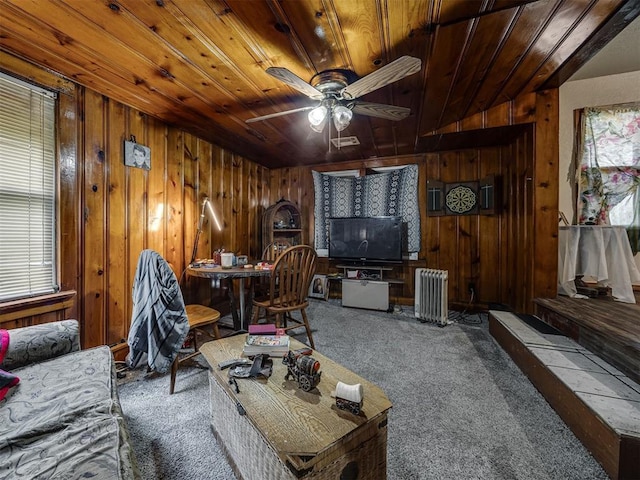 3236 SW 37th St, Oklahoma City, OK 73119 - carpeted living area featuring radiator heating unit, wooden ceiling, wood walls, and a ceiling fan