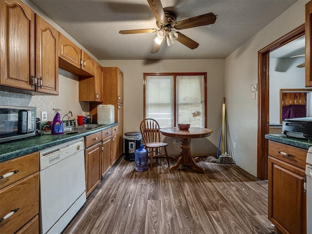 3236 SW 37th St, Oklahoma City, OK 73119 - kitchen with dishwasher, stainless steel microwave, dark wood finished floors, dark countertops, and a ceiling fan