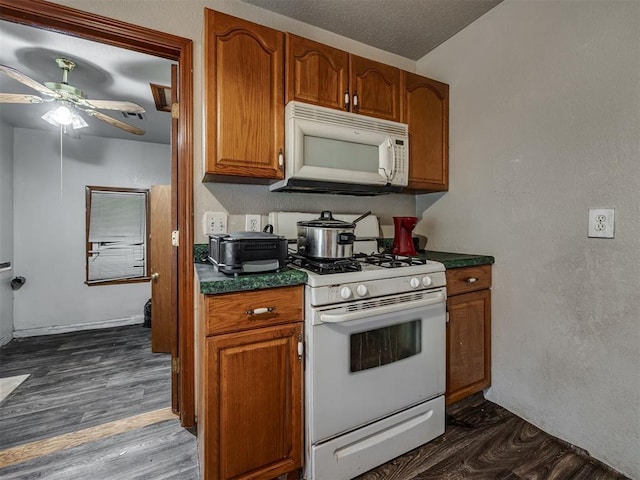 3236 SW 37th St, Oklahoma City, OK 73119 - kitchen featuring white appliances, dark countertops, ceiling fan, brown cabinetry, and a textured wall