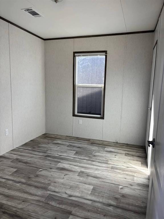 332841 E 890th Rd, Wellston, OK 74881 - unfurnished room featuring a decorative wall, wood finished floors, and ornamental molding