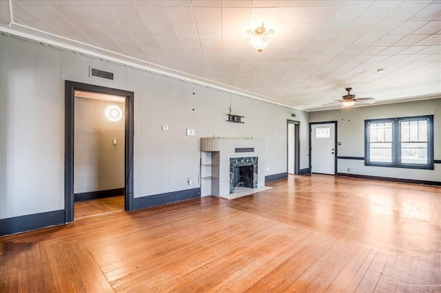 816 W Padon St, Blackwell, OK 74631 - unfurnished living room featuring ceiling fan, a fireplace with flush hearth, hardwood / wood-style floors, baseboards, and ornamental molding