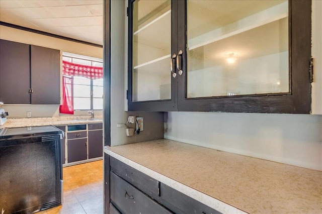 816 W Padon St, Blackwell, OK 74631 - kitchen with a sink, light countertops, stove, and glass insert cabinets