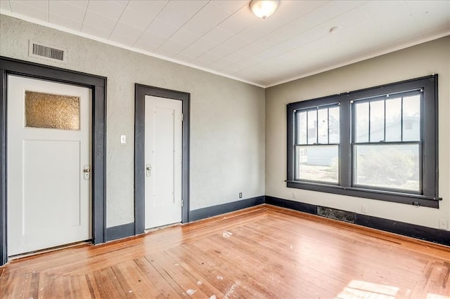 816 W Padon St, Blackwell, OK 74631 - empty room with crown molding, hardwood / wood-style flooring, and a textured wall