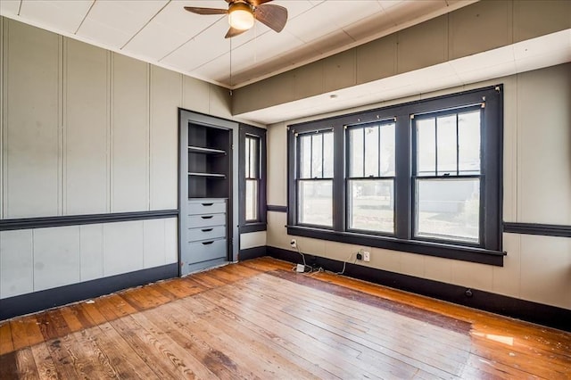 816 W Padon St, Blackwell, OK 74631 - empty room with hardwood / wood-style floors, a ceiling fan, and a decorative wall