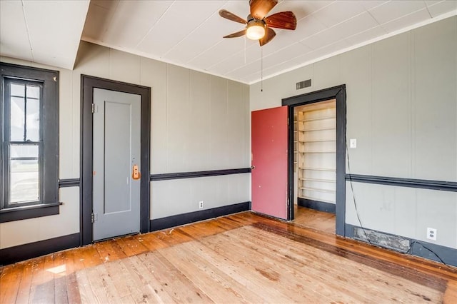 816 W Padon St, Blackwell, OK 74631 - empty room featuring hardwood / wood-style floors, ceiling fan, a decorative wall, and baseboards