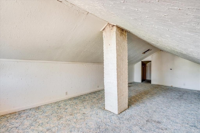 816 W Padon St, Blackwell, OK 74631 - bonus room featuring a textured ceiling, carpet flooring, vaulted ceiling, and baseboards