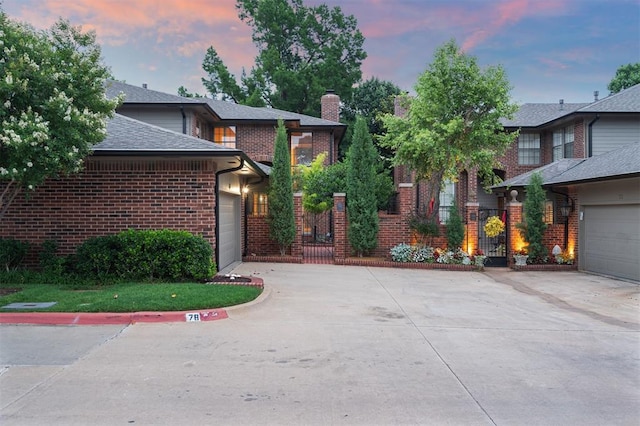 6206 Waterford Blvd Unit 78, Oklahoma City, OK 73118 - view of front of home with concrete driveway, an attached garage, a chimney, brick siding, and roof with shingles