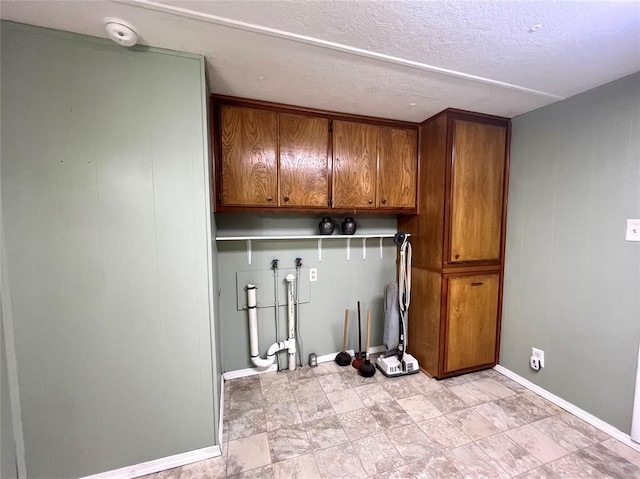 416 E Quail Rd, Chickasha, OK 73018 - washroom featuring cabinet space, washer hookup, baseboards, and a textured ceiling