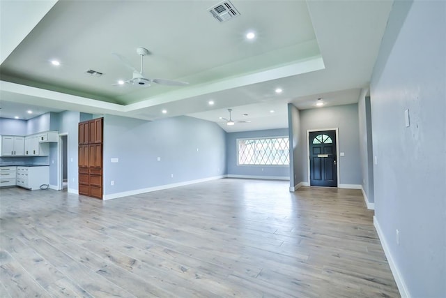 336 N Sherry Ave, Norman, OK 73069 - unfurnished living room with a tray ceiling, a ceiling fan, light wood-type flooring, and recessed lighting